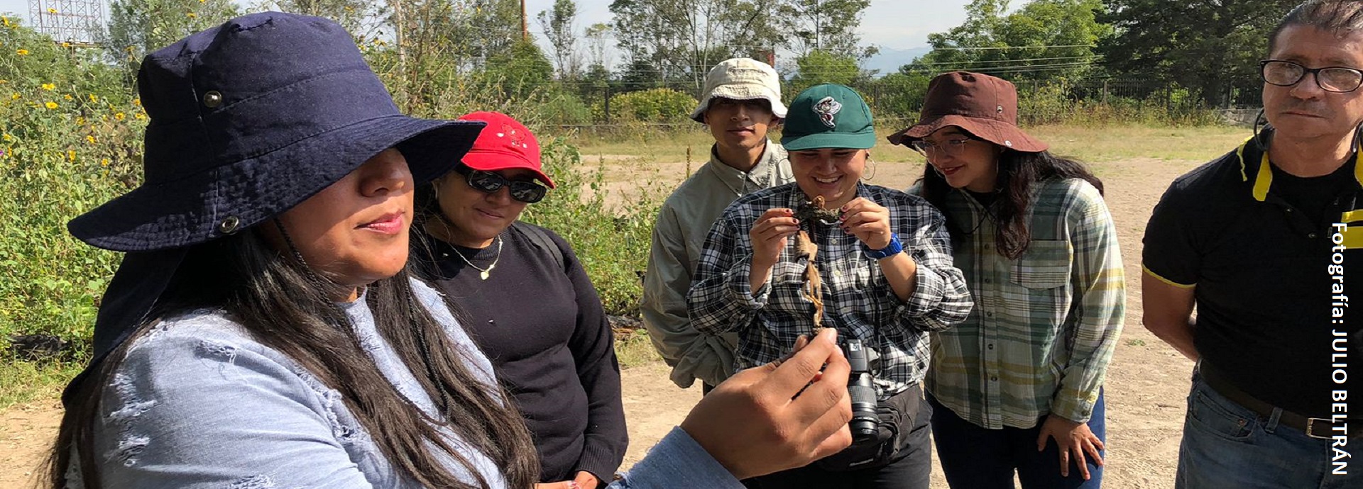 mujer joven mostrando un hongo a un grupo de estudiantes